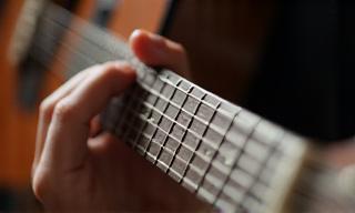 Detailed shot of guitar fretboard with student fingers in position